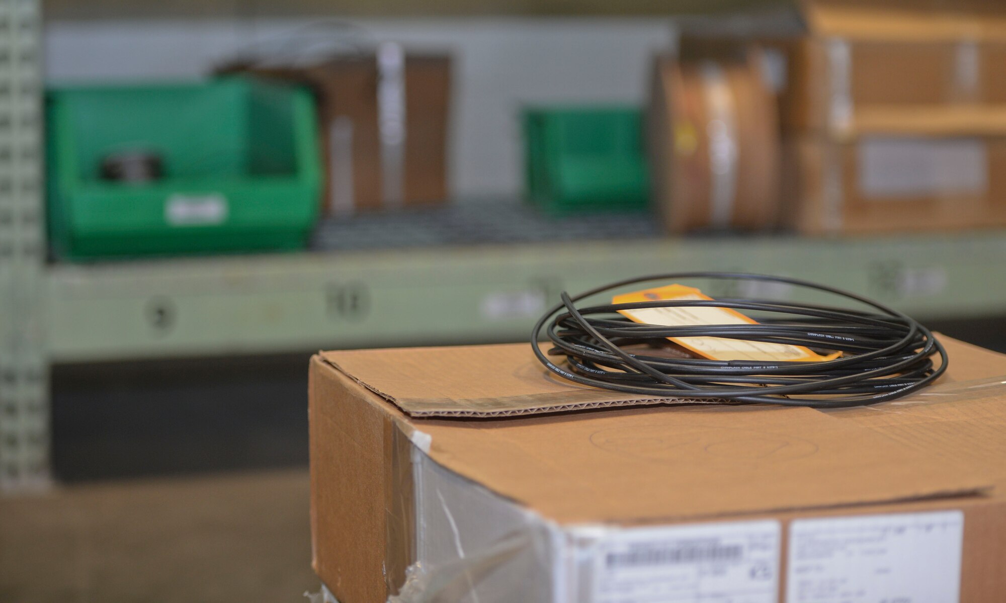 A roll of cable wires sits on a box after it has been tagged at the 22nd Logistics Readiness Squadron’s aircraft parts store at McConnell Air Force Base, Kan., July 29, 2015.  The aircraft parts store Airmen ensure Team McConnell’s maintenance shops get the parts required to provide crucial maintenance for the KC-135 Stratotanker to accomplish its mission. (U.S. Air Force photo by Senior Airman Colby Hardin)