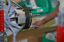 Airman 1st Class Arrielle Conver, 22nd Logistics Readiness Squadron aircraft parts store journeyman, rolls cables back into the inventory, July 29, 2015, at McConnell Air Force Base, Kan. The Airmen in the aircraft parts store ensure the aircraft maintenance shop gets the parts required to provide crucial maintenance for the KC-135 Stratotanker to accomplish its mission. (U.S. Air Force photo by Senior Airman Colby Hardin)