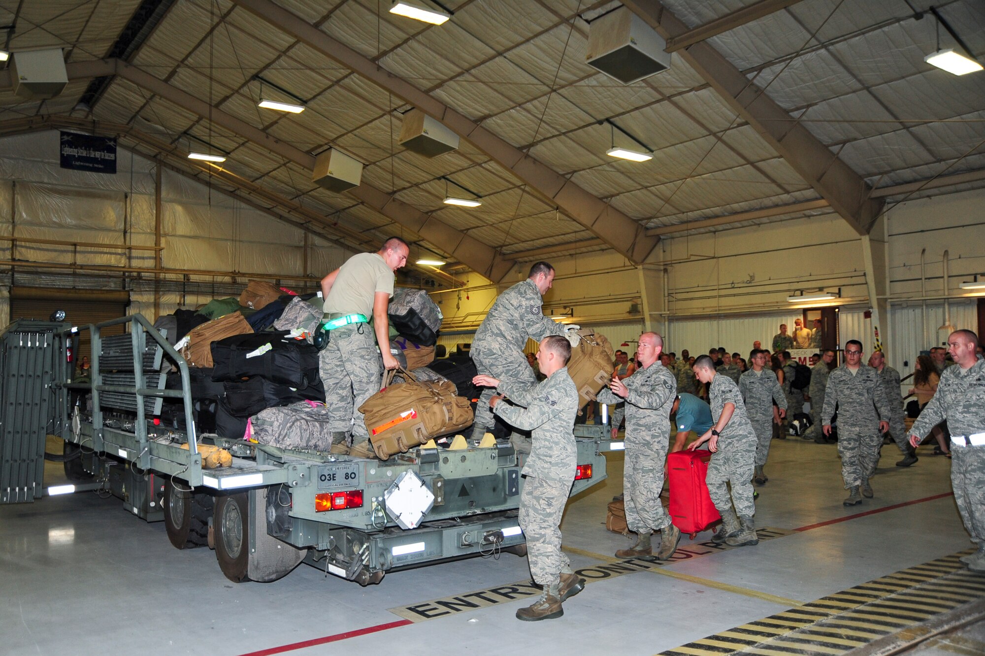 U.S. Air Force Airmen unload their luggage inside a hangar at Davis-Monthan Air Force Base, Ariz., after returning home from a six month deployment July 29, 2015. More than 200 Airmen returned from supporting the first European Theater Security Package in support of Operation Atlantic Resolve. (U.S. Air Force photo by Senior Airman Chris Massey/Released)