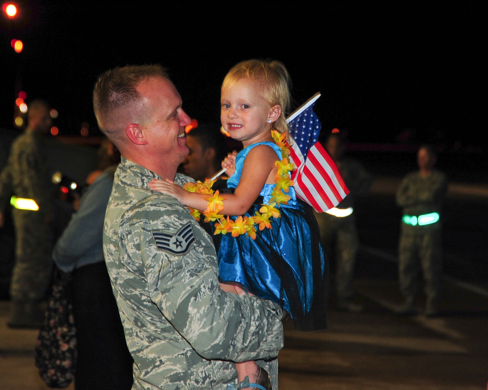 U.S. Air Force Staff Sgt. Bryan Kessler, 355th Maintenance Group A-10 Thunderbolt II quality assurance inspector, holds daughter, Lilah, at Davis-Monthan Air Force Base, Ariz., after returning home from a six month deployment July 29, 2015. Kessler was deployed as part of the first European Theater Security Package in support of Operation Atlantic Resolve. (U.S. Air Force photo by Senior Airman Chris Massey/Released)