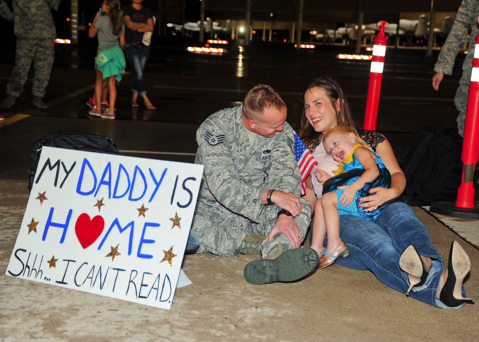 U.S. Air Force Staff Sgt. Bryan Kessler, 355th Maintenance Group A-10 Thunderbolt II quality assurance inspector, shares a moment with his wife, Danielle, and daughter, Lilah, at Davis-Monthan Air Force Base, Ariz., after returning home from a 6-month deployment July 29, 2015. Kessler deployed as part of the first European Theater Security Package in support of Operation Atlantic Resolve.  (U.S. Air Force photo by Senior Airman Chris Massey/Released)