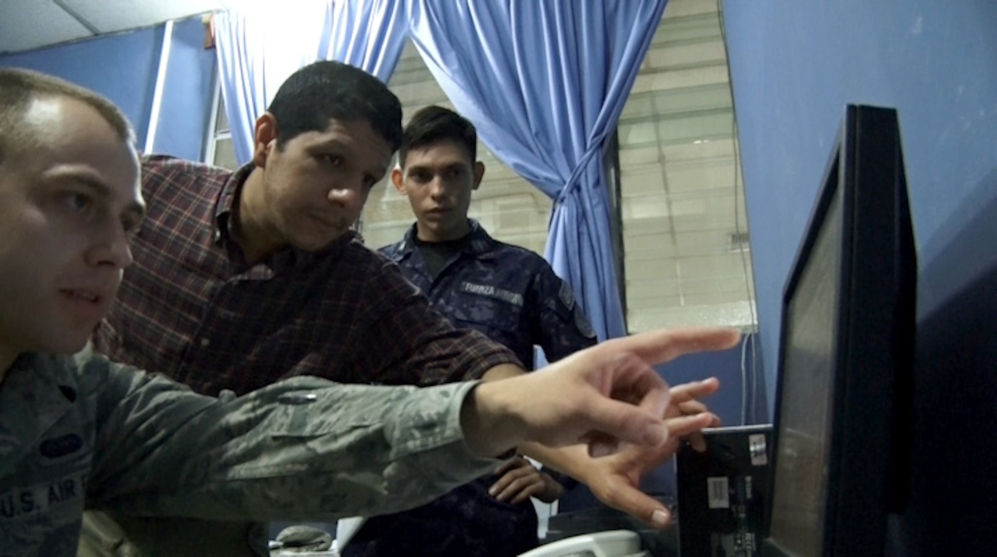 U.S. Air Force Staff Sgt. Alan Dwyer (left), cyber operations and network administrator with the New Hampshire Air National Guard, learns about the Salvadoran military network as Josue Bautista translates for Salvadoran Air Force Sgt. Jose Javier Alvarado Orellana. Airmen from the 157th Communications Flight spent a week in El Salvador, July 21 through 24, discussing cybersecurity as part of the on-going New Hampshire state partnership program with El Salvador. (N.H. Air National Guard photo  by Tech. Sgt. Erica Rowe)