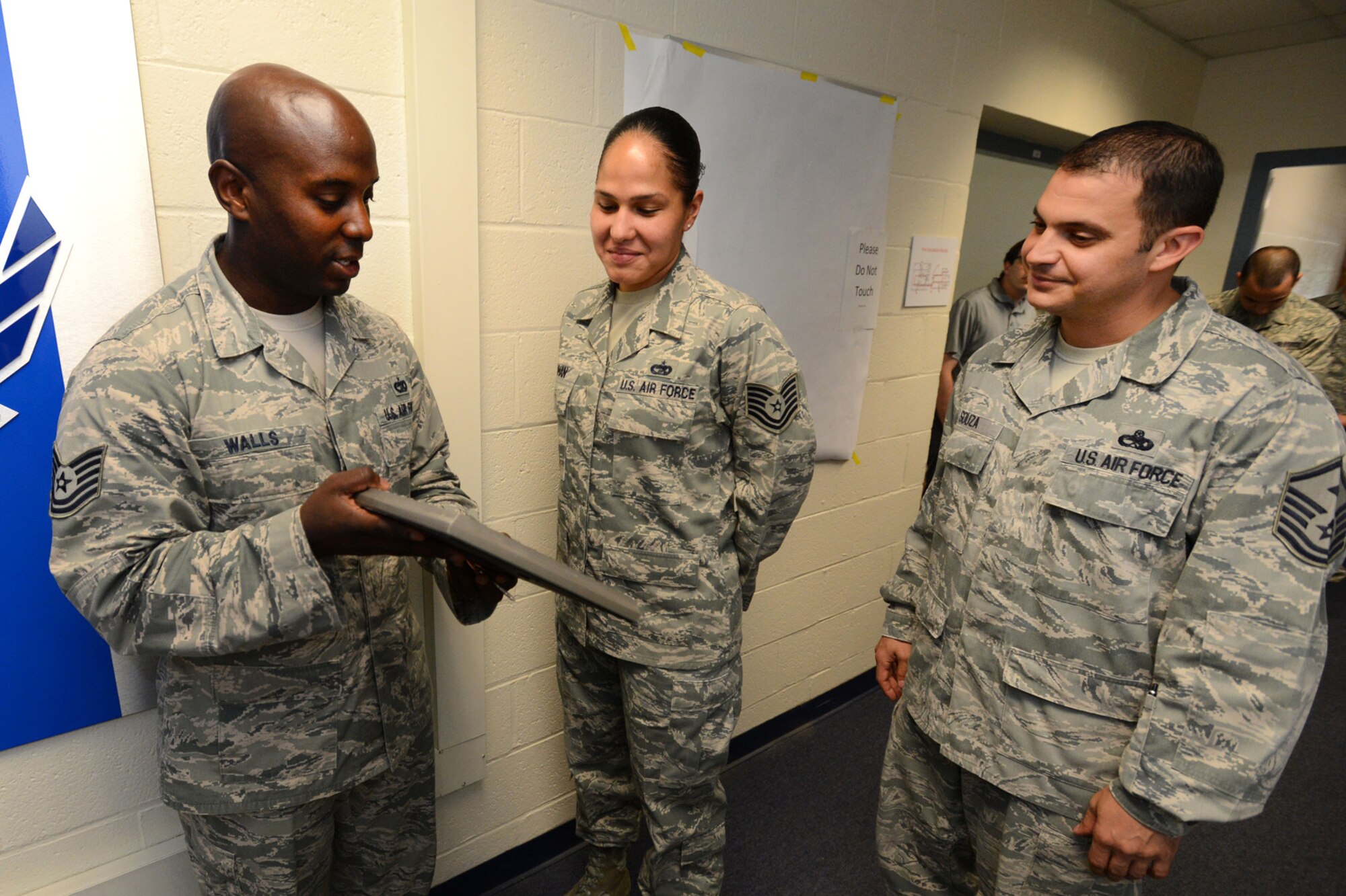 Tech Sgt. David Walls, Joint Personal Property Shipping Office-Northeast Storage Management NCO in charge, presents the Diamond Sharp Award to Tech. Sgt. Eleuteria Inman, JPPSO-NE Movement Support NCO in charge, as Master Sgt. Nicholas Souza, 66th Comptroller Squadron and 66th Air Base Group Staff Agency first sergeant, watches during an impromptu ceremony at JPPSO, July 30. The Hanscom first sergeants selected Inman as the recipient of the award for performance reflecting the highest standard of professionalism and pride. The Diamond Sharp program, adopted by the First Sergeant Council, aims to recognize the base’s sharpest personnel in the grades of airman basic through technical sergeant. (U.S. Air Force photo by Jerry Saslav)