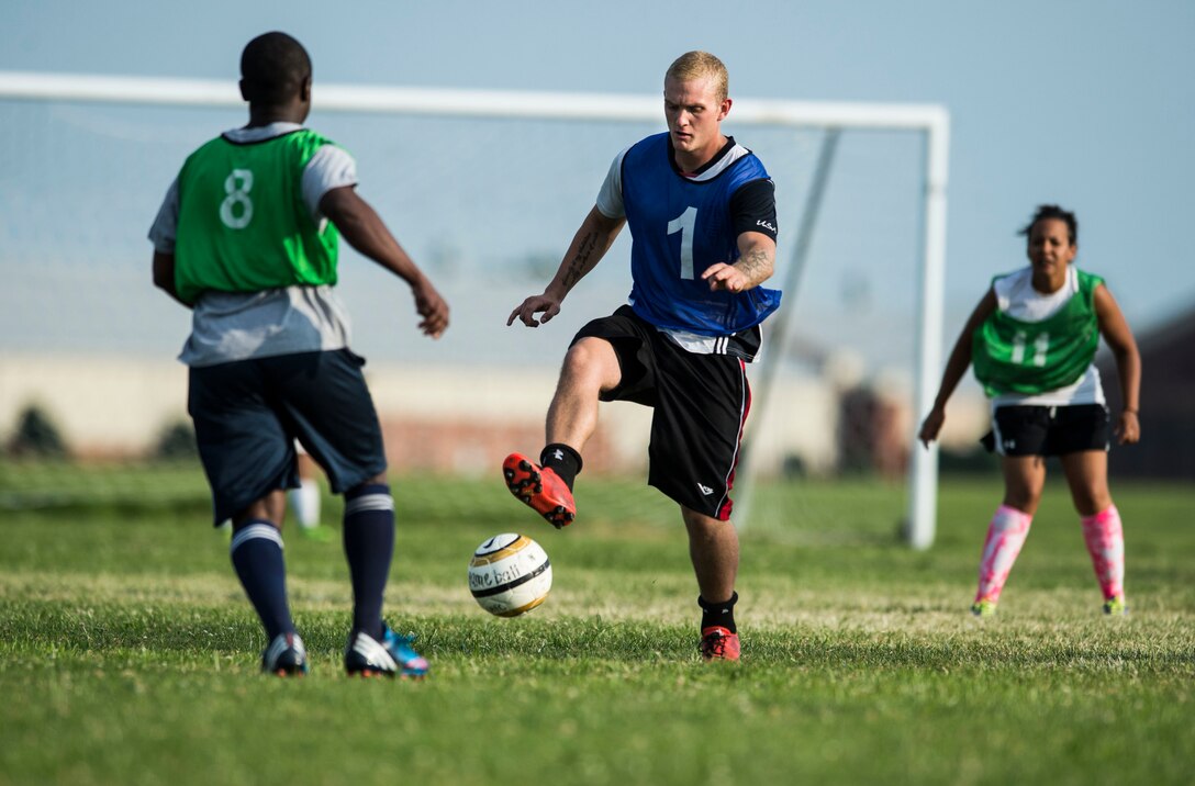 U.S. Air Force Airmen from the 633rd Medical Group and Civil Engineer Squadron compete in the 2015 Intramural Soccer Championship game at Langley Air Force Base, Va., July 28, 2015. After two games, the 633rd MDG took home the 1st place trophy, presented by Col. Caroline Miller, 633rd Air Base Wing commander. (U.S. Air Force photo by Senior Airman Kayla Newman/Released)