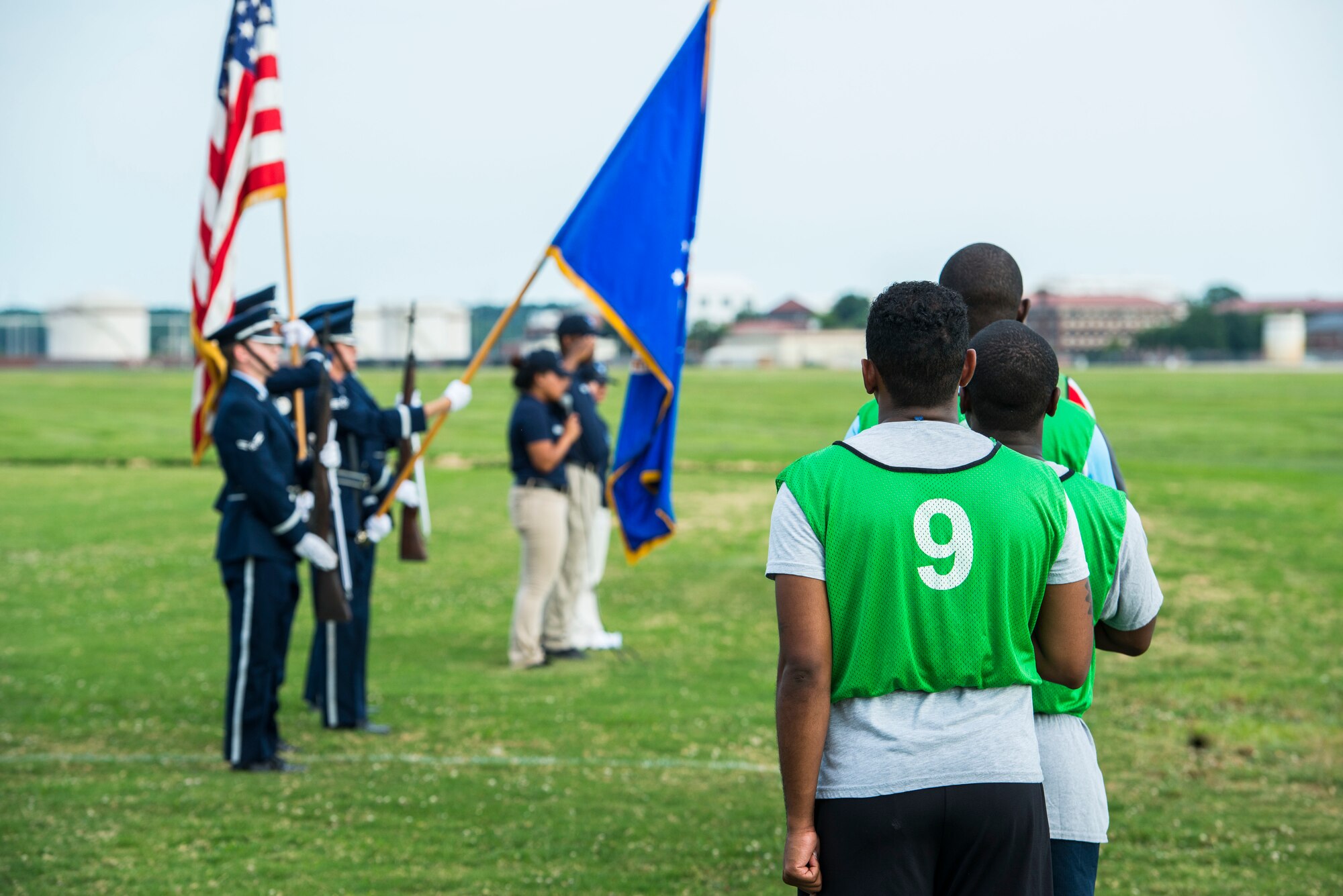 U.S. Air Force Service members pay respects to the National Anthem prior to the 2015 Intramural Soccer Championship game at Langley Air Force Base, Va., July 28, 2015. The game pitted the 633rd Medical Group against the 633rd Civil Engineer Squadron. (U.S. Air Force photo by Senior Airman Kayla Newman/Released)