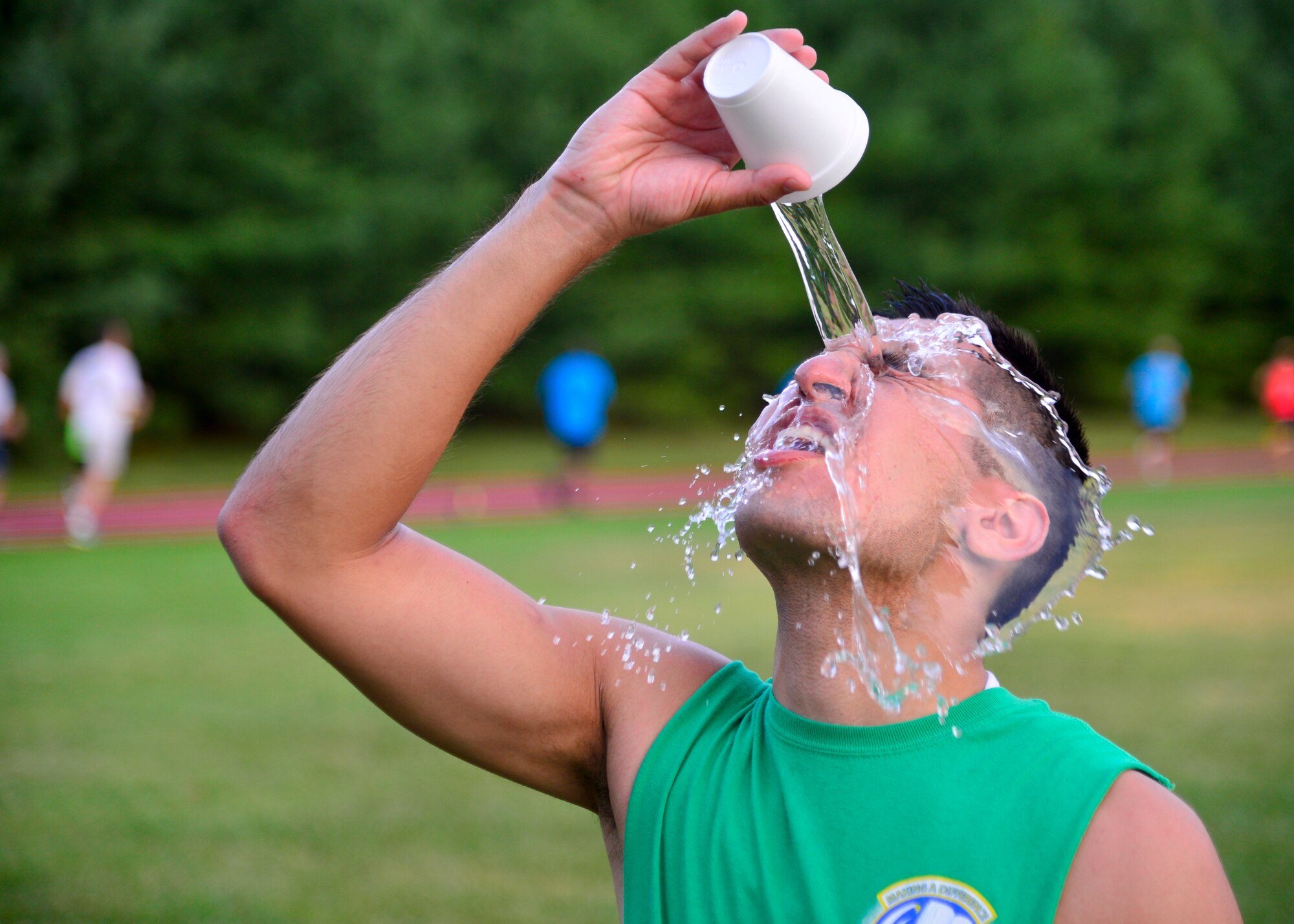 Senior Airman Nicolas Casabianca Alvarez, 436th Comptroller Squadron financial services technician, pours water on his face after finishing the 5K Warrior Run July 30, 2015, at the track on Dover Air Force Base, Del. The base track reopened after being renovated and features a plexitrac accelerator surface that is highly textured for optimum traction. (U.S. Air Force photo/Airman 1st Class William Johnson)