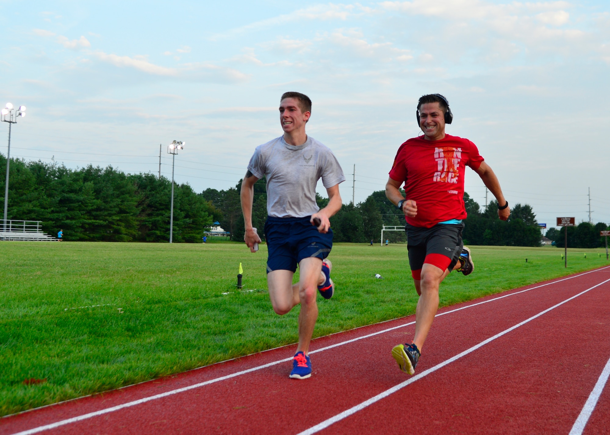 Airman Jason Perry, 436th Maintenance Squadron aircraft structural maintenance, left, and Capt. Bernie Kale, 512th Public Affairs chief, right, race each other to the finish line of the 5K Warrior Run July 30, 2015, at the track on Dover Air Force Base, Del. The track was renovated and has been NCAA certified as a four lap mile track. (U.S. Air Force photo/Airman 1st Class William Johnson)
