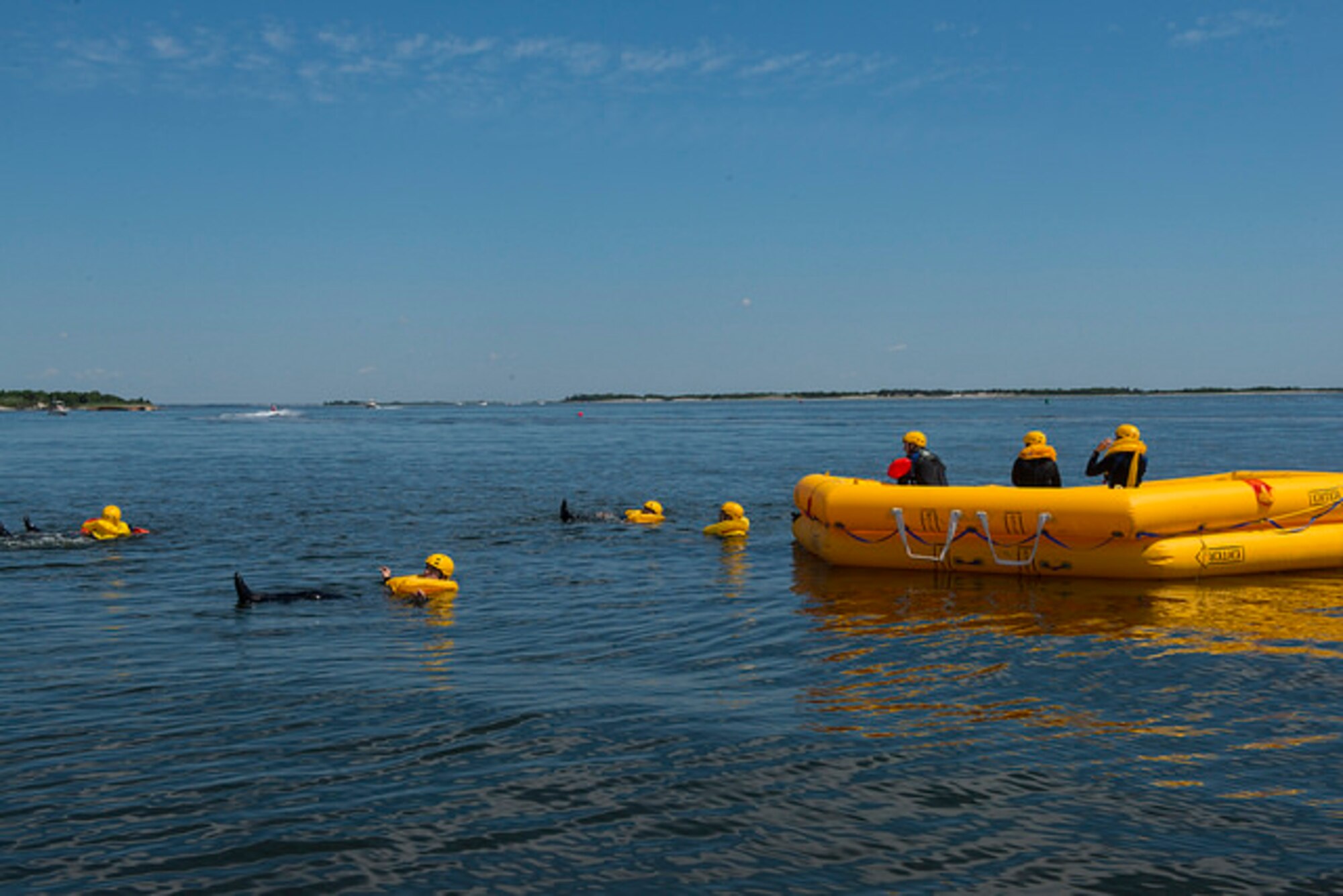 Members of the 305th Air Mobility Wing swim toward a raft during water survival training in Barnegat, N.J. July 23, 2015. Water survival training is mandatory once every three years and focuses on teaching aircrews what to do when an aircraft goes down in the water, from proper use of flotation devices to all procedures and equipment involved with the life rafts in the aircraft. (U.S. Air Force photo by Airman 1st Class Joshua King/ released)