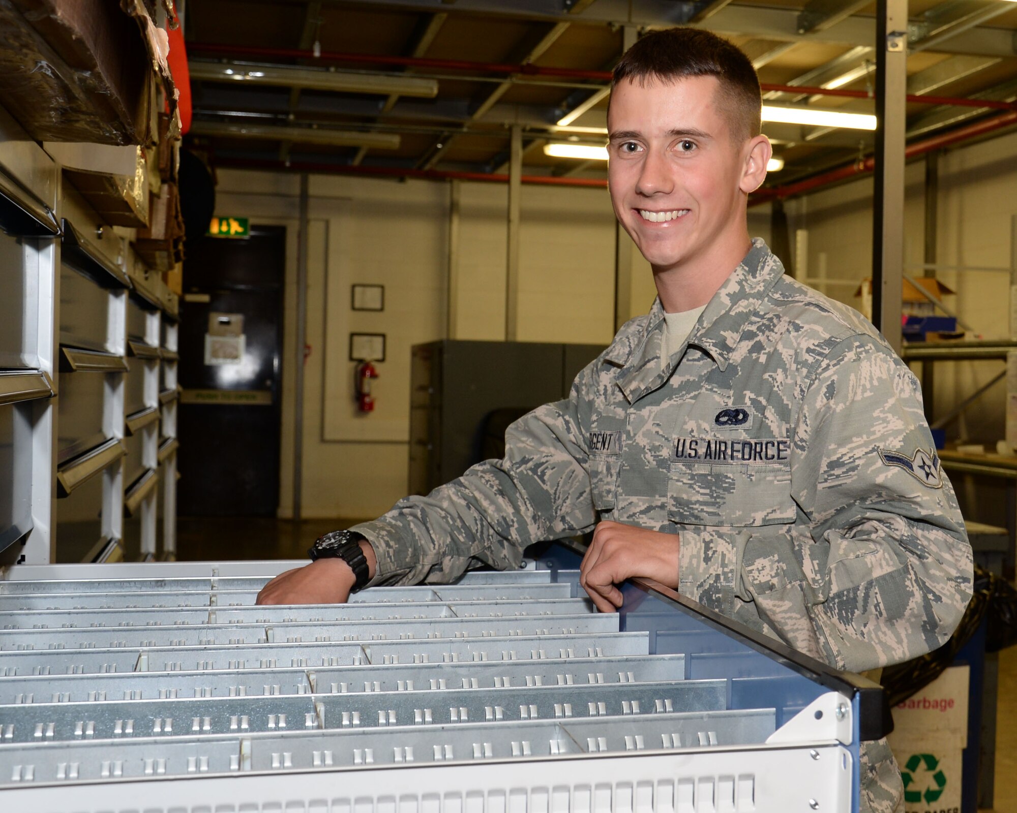 U.S. Air Force Airman Logan Sargent, 100th Aircraft Maintenance Squadron KC-135 Stratotanker aircraft maintenance apprentice from Guilford, Maine, poses for a photograph while looking for hardware for an aircraft July 28, 2015, on RAF Mildenhall, England. Sargent was selected for the Square D Spotlight for portraying the core value of Excellence in All We Do. (U.S. Air Force photo by Gina Randall/Released)