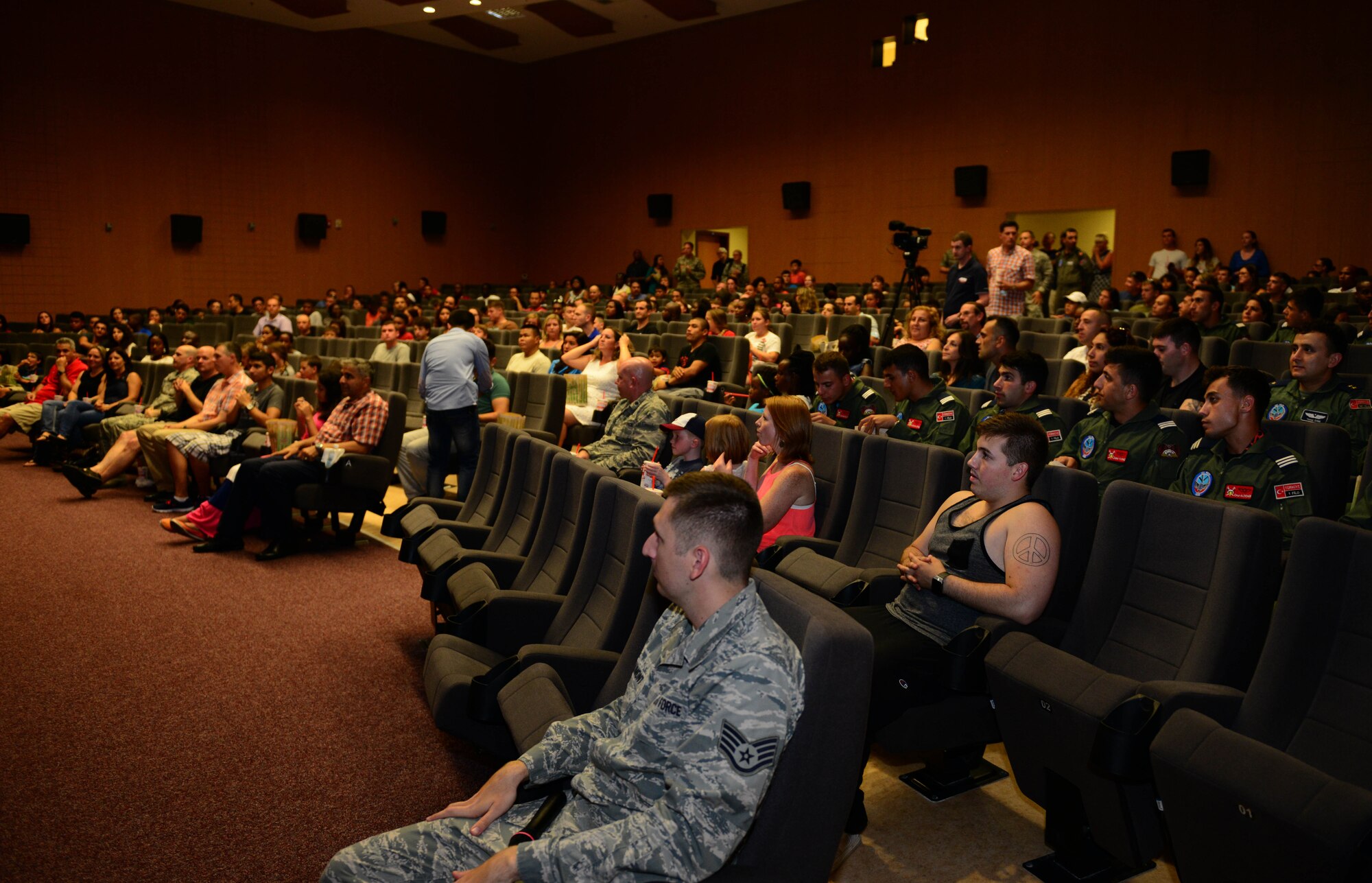 U.S. and Turkish personnel and their families await the ribbon cutting of the new base community center July 29, 2015, at Incirlik Air Base, Turkey. Brig. Gen. Bekir Ercan Van, 10th Tanker Base Command commander, and Col. Craig Wills, 39th Air Base Wing commander, cut the ribbon. (U.S. Air Force photo by Staff Sgt. Caleb Pierce/Released) 