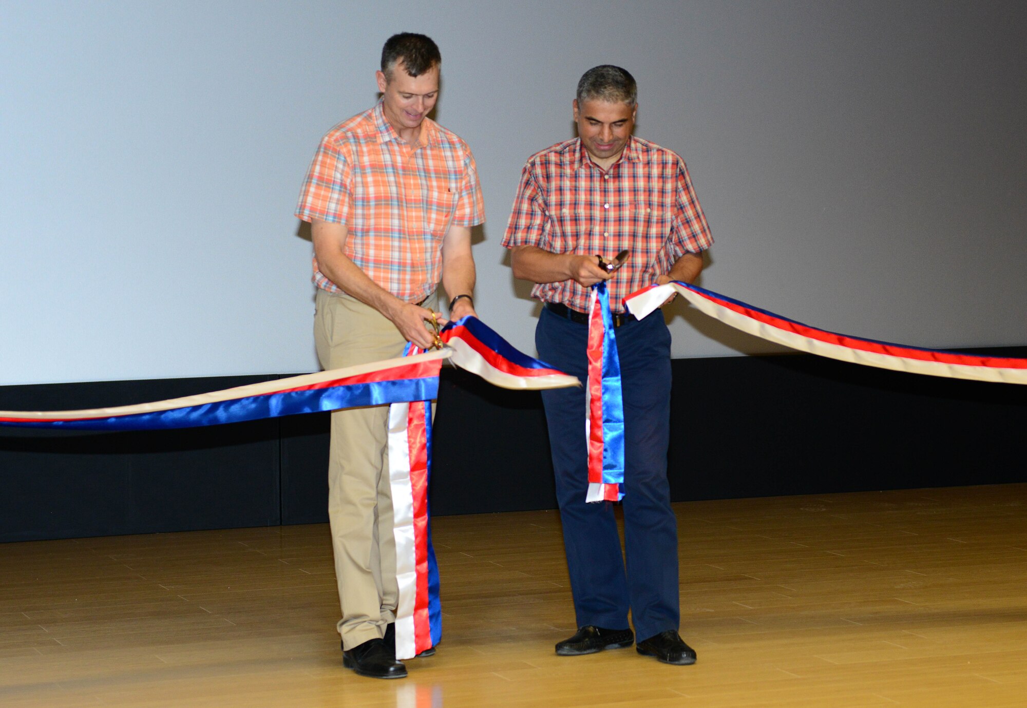 Brig. Gen. Bekir Ercan Van, 10th Tanker Base Command commander, and Col. Craig Wills, 39th Air Base Wing commander, cut a ribbon to open the new base community center July 29, 2015, at Incirlik Air Base, Turkey. The soft opening included remarks from the commanders, a ribbon cutting and a free movie. (U.S. Air Force photo by Staff Sgt. Caleb Pierce/Released)