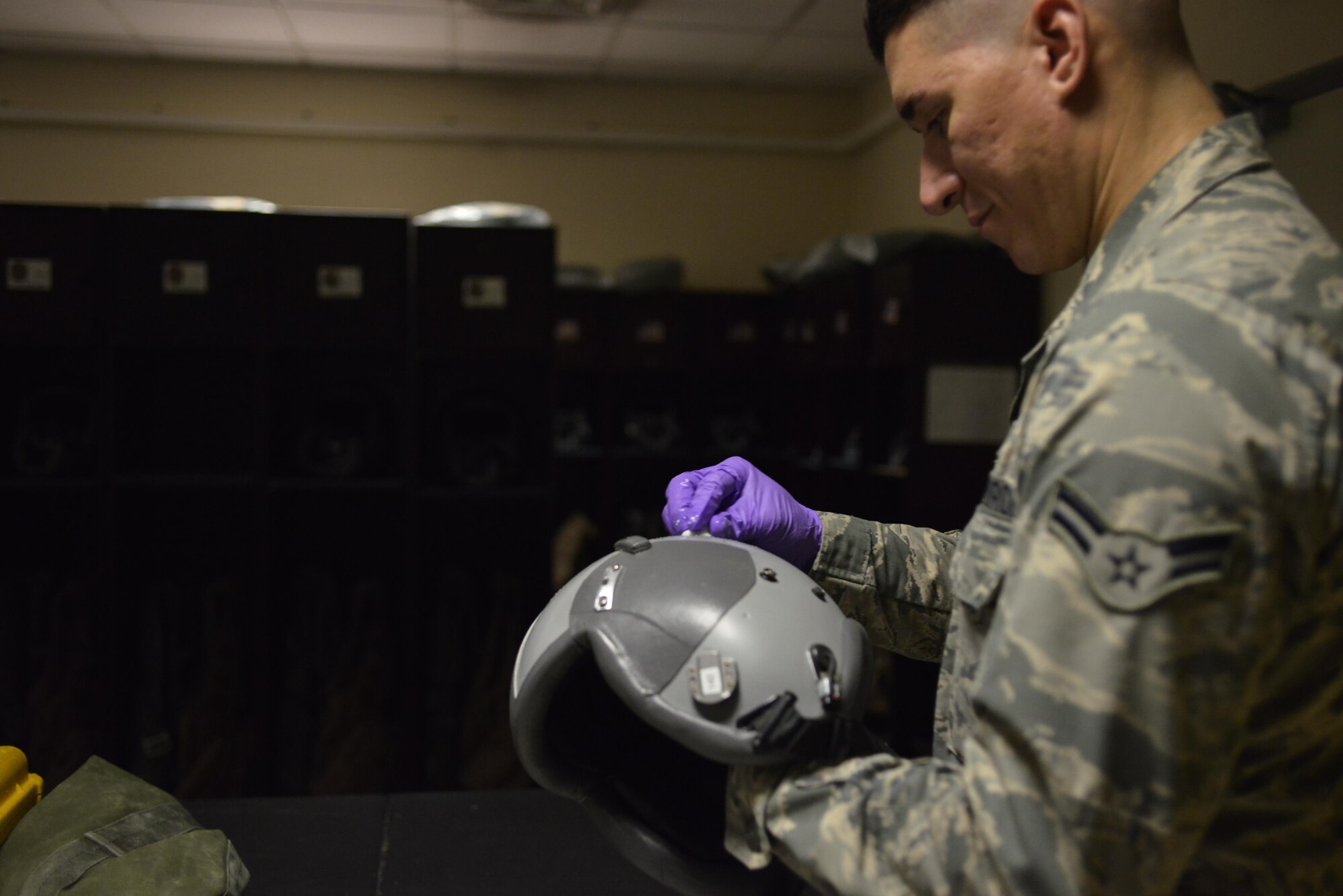 Airman 1st Class Andrew Gonzalez, 379th Expeditionary Operations Support Squadron Aircrew Flight Equipment, sanitizes an aircrew member’s helmet during routine maintenance July 29, 2015 at Al Udeid Air Base, Qatar. AFE airmen are responsible for helmet harnesses, life preservers and parachutes.  They also ensure aircrew members are properly armed prior to takeoff and clear them after each mission. (U.S. Air Force photo/Staff Sgt. Alexandre Montes)