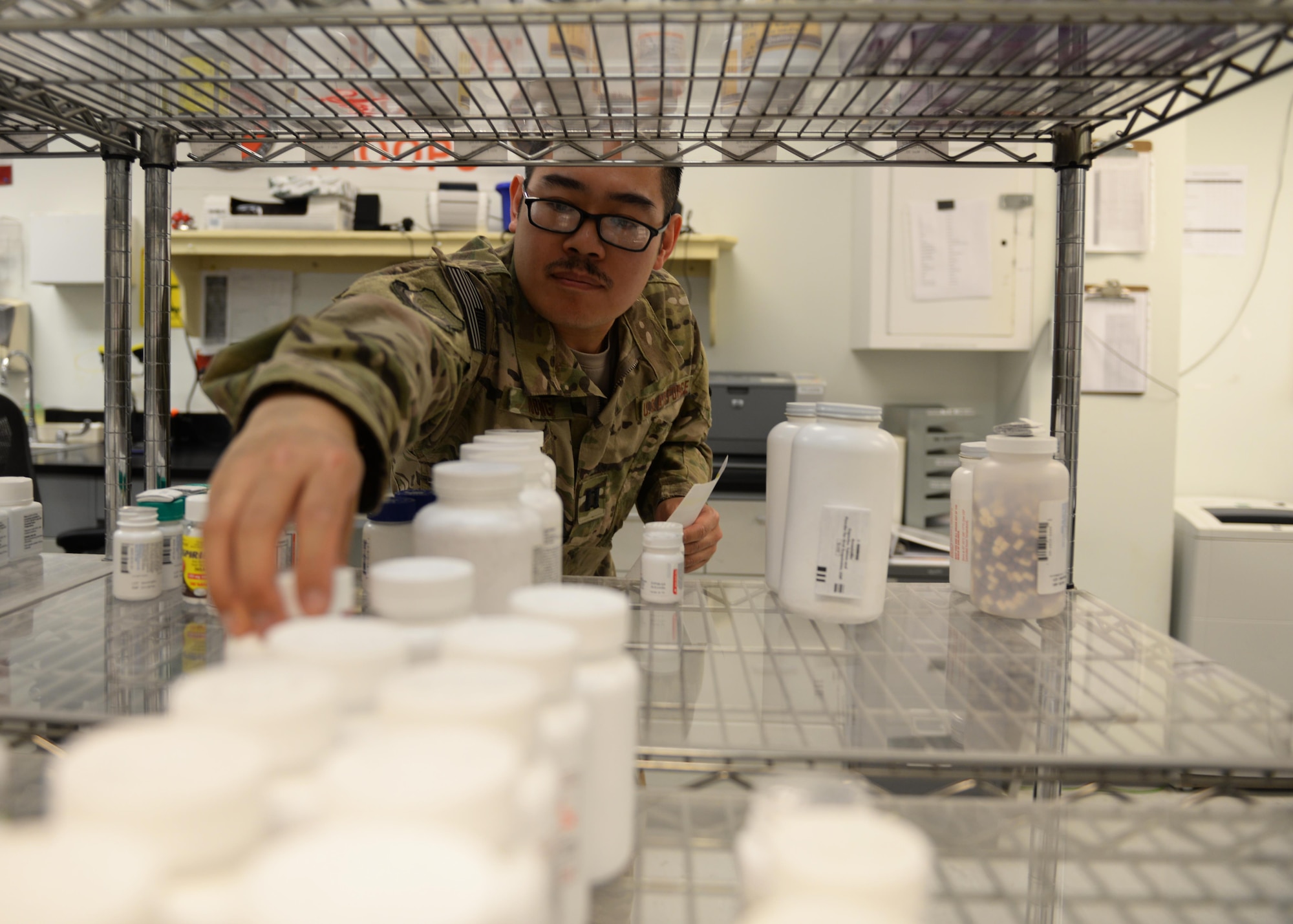 U.S. Air Force Capt. David Voung, 455th Expeditionary Medical Operations Squadron pharmacist, reaches for medication July 31, 2015, at Bagram Airfield, Afghanistan. Vuong is responsible for keeping the pharmacy fully stocked with medications to treat patients at Bagram keeping them fit to fight and support the mission. (U.S. Air Force photo by Senior Airman Cierra Presentado/Released)