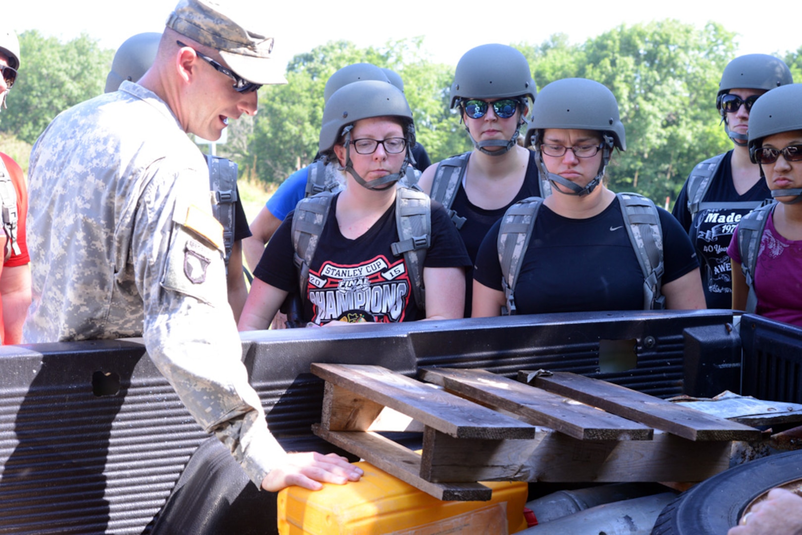 Sgt. 1st Class Joshua Nickels of Montgomery, Illinois, a training assistor for the Illinois Pre-Mobilization Training Assistance Element, shows an improvised explosive device in the back of pickup on the training IED lane to civilians during "Military Immersion" training, July 17, 2015, at Marseilles Training Center, Marseilles, Illinois.