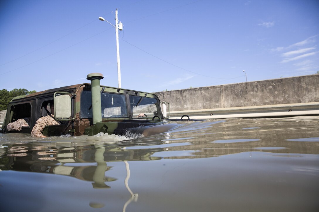 Marines with Marine Wing Support Squadron 272 nearly submerge a Humvee as they drive through a water-filled fording pit aboard Camp Johnson, N.C., July 28, 2015. As part of their training, Marines gained experience in ensuring unit readiness by maneuvering through the obstacle as their vehicle fills with water. (U.S. Marine Corps photo by Lance Cpl. Aaron K. Fiala/Released)