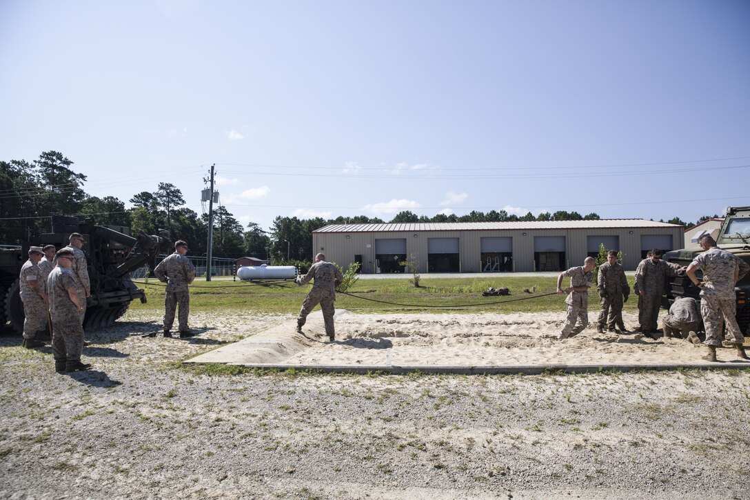 Marines with Marine Wing Support Squadron 272 attach a winch cable to the front of a Medium Tactical Vehicle Replacement, also known as a 7-ton, to pull the vehicle out of a sand pit aboard Camp Johnson, N.C., July 28, 2015. As part of their training, these Marines gained experience in recovering large military vehicles from a sand pit or other simulated terrain. (U.S. Marine Corps photo by Lance Cpl. Aaron K. Fiala/Released)