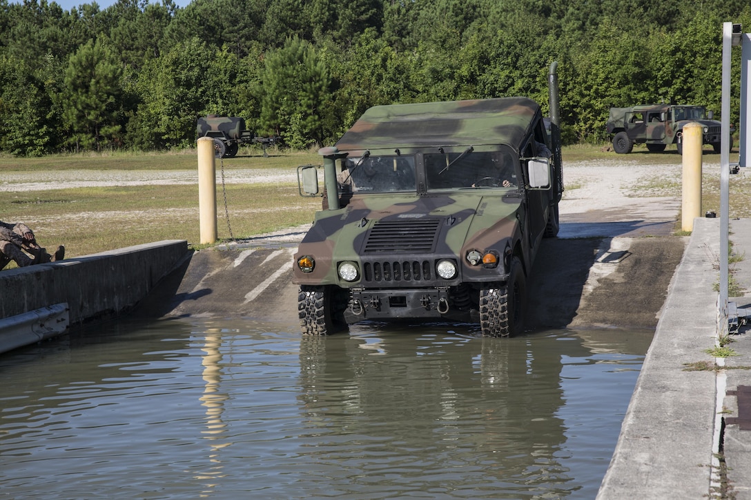 Marines with Marine Wing Support Squadron 272 drive a Humvee into a water-filled fording pit aboard Camp Johnson, N.C., July 28, 2015. As part of their training, Marines gained experience in ensuring unit readiness by maneuvering through the obstacle as their vehicle fills with water. (U.S. Marine Corps photo by Lance Cpl. Aaron K. Fiala/Released)