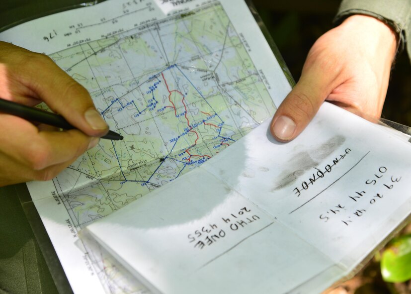 Senior Airman Leo Avila, a C-5M Super Galaxy engineer assigned to the 709th Airlift Squadron, uses coordinates to mark his crew’s position on a map during a combat survival training exercise July 16, 2015, at the Blackbird State Forest near Smyrna, Del. The crew was equipped with a compass and a map to navigate several miles of woodland and marsh terrain during the exercise. (U.S. Air Force photo/Airman 1st Class William Johnson) 