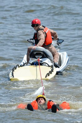Master Sgt. Joshua Mal, a C-17A Globemaster III loadmaster assigned to the 3rd Airlift Squadron, keeps his head above water as Staff Sgt. Adam Ellerd, the 436th Operations Support Squadron Survival, Evasion, Resistance and Escape Operations NCO in charge, looks over his shoulder from a personal watercraft to see when and if Mal successfully releases from his harness July 17, 2015, near Dover Air Force Base, Del. Mal and other students had to find and release their torso harness fittings while being towed through the water to simulate being dragged by their canopy after landing in water. (U.S. Air Force photo/Greg L. Davis) 