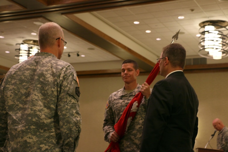 Col. John W. Henderson holds the flag of the U.S. Army Corps of Engineers accepting his new assignment as commander of the Omaha District in a ceremony held July 31 in Omaha, Neb.