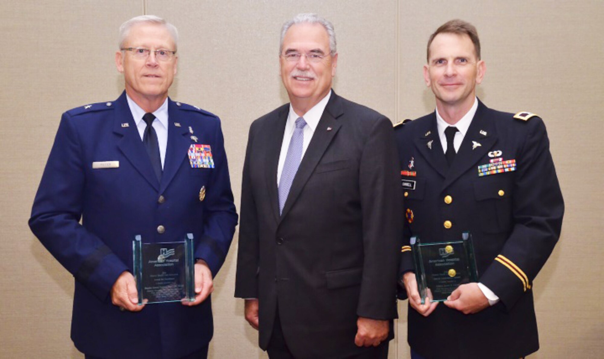 Retired Air Force Brig. Gen. Charles Potter (left) and Army Col. James Carrell (right) received their awards for their service to the health care field from Richard Umbdenstock, American Hospital Association president and CEO.