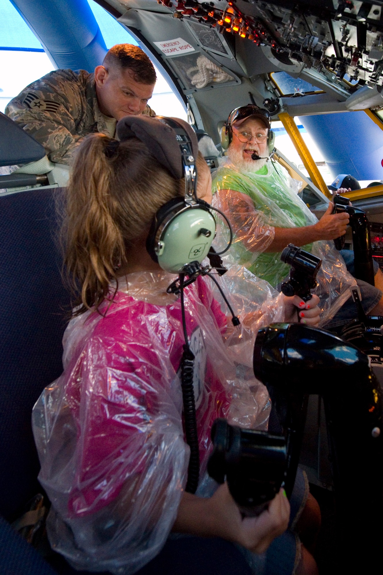 John Hickman speaks to his granddaughter, Alexiya Hickam, at the controls of a KC-135R Stratotanker interactive flight deck while Staff Sgt. Joe Meyer, 434th Aircraft Maintenance Squadron crew chief, stands by to answer questions during the Dayton Vectron Airshow in Dayton, Ohio, June 20, 2015. During the event, Meyer and seven other Airmen volunteered to setup up and operate the displays while sharing their military knowledge with visitors. (U.S. Air Force photo/Tech. Sgt. Benjamin Mota)
