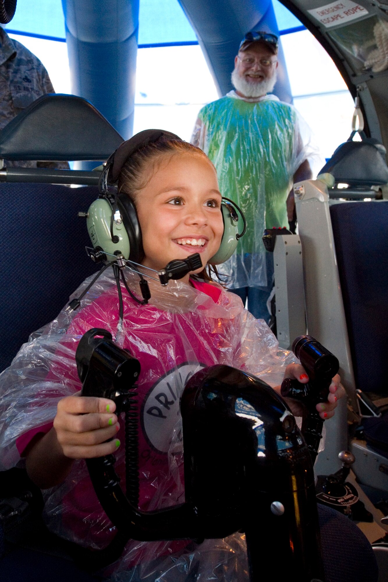 Alexiya Hickman takes her turn at the controls of a KC-135R Stratotanker interactive flight deck as her grandfather, John Hickman, observes during the Dayton Vectron Airshow in Dayton, Ohio, June 20, 2015. Over the course of the two-day event, approximately 3,000 people toured the displays. (U.S. Air Force photo/Tech. Sgt. Benjamin Mota)
