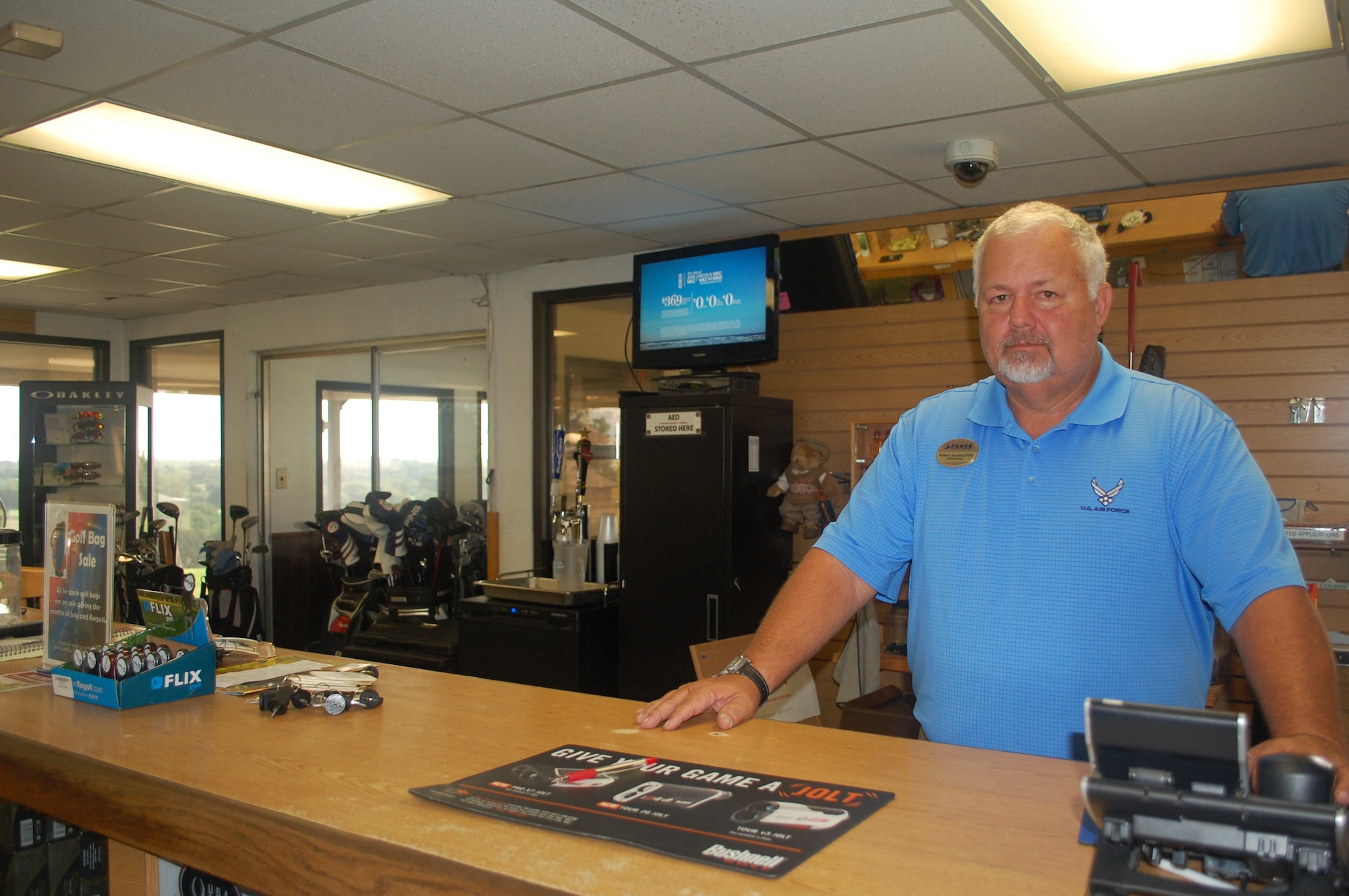 Gateway Hills Golf Course facility manager Robert Jacobus runs the counter at the pro shop July 20, 2015, and talks about the Golf Enterprise  Solution at JBSA San Antonio-Lackland, Texas.(U.S. Air Force photo/Carole Chiles Fuller/RELEASED)