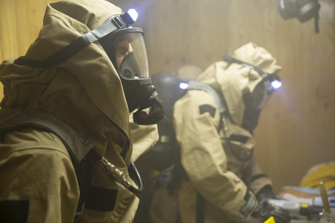 Lance Cpl. Cameron Q. Bemis (left), a chemical, biological, radiological and nuclear defense specialist with 4th Light Armored Reconnaissance Battalion, 4th Marine Division, pauses from sample collection during the final training event of the Advanced Consequence Management Team Certification in Pilottown, La., July 29, 2015. The Marines were part of a survey team sent in to take samples from a simulated methamphetamine laboratory. (U.S. Marine Corps photo by Cpl. Ian Leones/Released)