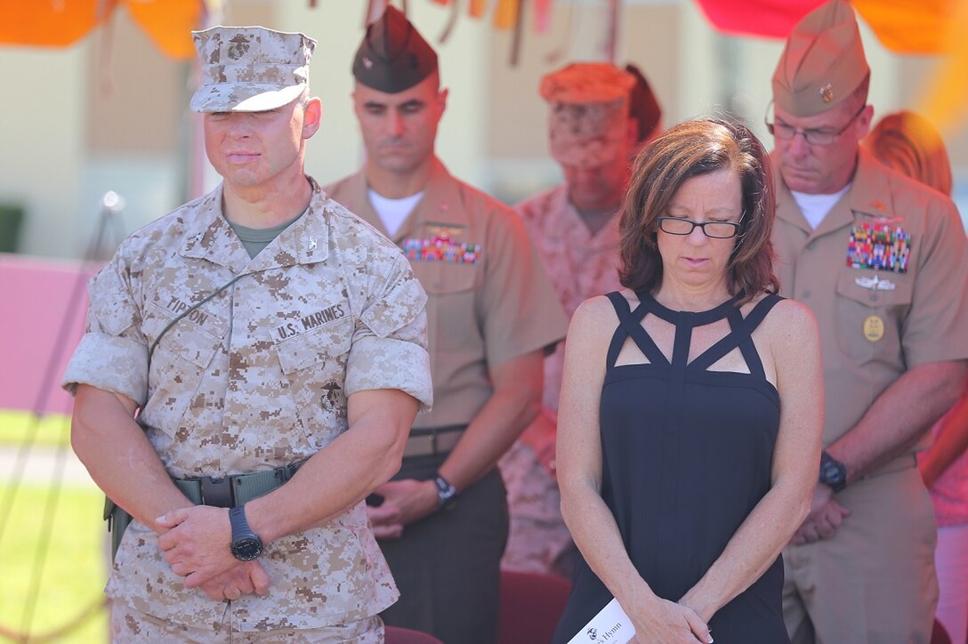 U.S. Marine Corps Col. Clay C. Tipton, left, and his wife Julie bow their heads during the invocation for a change of command ceremony aboard Camp Pendleton, Calif., July 17. U.S. Marine Corps Col. Matthew G. Trollinger relinquished his command of the 11th MEU to Tipton. (U.S. Marine Corps photo by Cpl. Jonathan R. Waldman/Released)