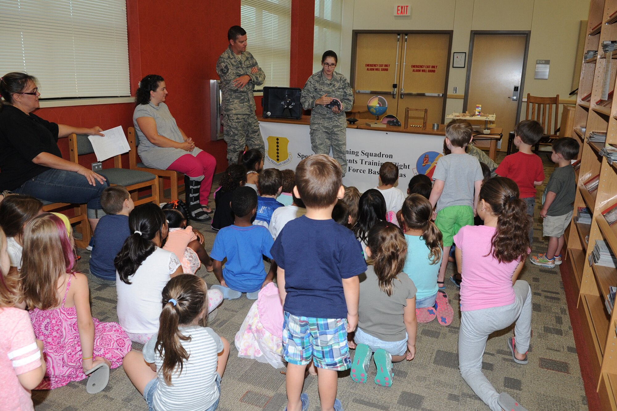 U.S. Air Force Staff Sgt. Natasha M. Mattoon, 312th Training Squadron special instruments training instructor, shows Goodfellow youth an interior model globe of the earth during a SPINSTRA demonstration at the Consolidated Learning Center, Goodfellow Air Force Base, Texas, July 28, 2015. The SPINSTRA team used several items to demonstrate science to include an earthquake table, a Slinky and florescent light bulb.  (U.S. Air Force photo by Staff Sgt. Laura R. McFarlane/ Released)