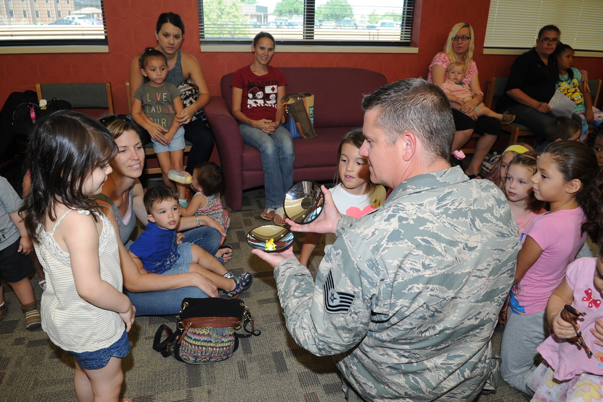 U.S. Air Force Tech. Sgt. Brian P. Ferestad, 312th Training Squadron special instruments training instructor, shows Goodfellow youth a mirascope during a SPINSTRA demonstration at the Consolidated Learning Center, Goodfellow Air Force Base, Texas, July 28, 2015. The mirascope creates a hologram that looks real by using light reflection. (U.S. Air Force photo by Staff Sgt. Laura R. McFarlane/ Released)