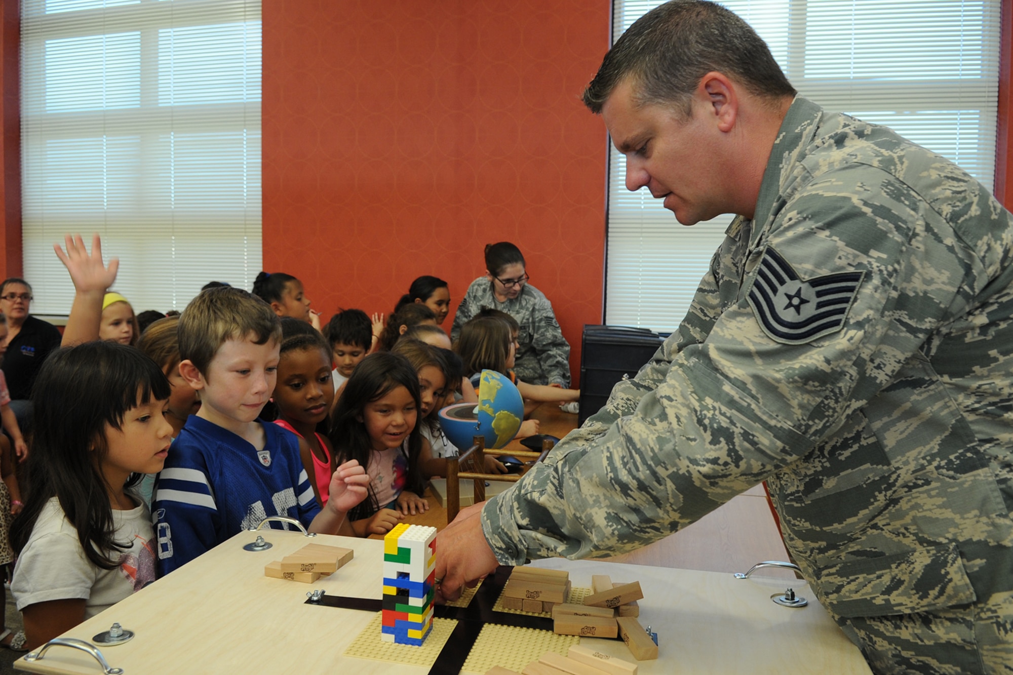 U.S. Air Force Tech. Sgt. Brian P. Ferestad, 312th Training Squadron special instruments training instructor, sets up a Jenga tower, as a non-reinforced building, to show Goodfellow youth the effects earthquakes can have on non-reinforced versus reinforced buildings during a SPINSTRA demonstration at the Consolidated Learning Center, Goodfellow Air Force Base, Texas, July 28, 2015. The purpose of the demonstration was to get youth interested in science, technology, engineering and mathematics otherwise known as STEM. (U.S. Air Force photo by Staff Sgt. Laura R. McFarlane/ Released)