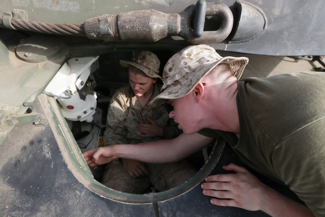 ARTA BEACH, Djibouti (July 24, 2015)  U.S. Marine Lance Cpl. Paul Shabel, right, shows Lance Cpl. Jacob Bowen, left, the driver controls of an M1A1 Abrams tank. Shabel is a tank driver with Battalion Landing Team 3rd Battalion, 1st Marine Regiment, 15th Marine Expeditionary Unit, and Bowen is a rifleman with BLT 3/1, 15th MEU. Elements of the 15th Marine Expeditionary Unit are ashore in Djibouti for sustainment training to maintain and enhance the skills they developed during their pre-deployment training period.  The 15th MEU is currently deployed in support of maritime security operations and theater security cooperation efforts in the U.S. 5th and 6th Fleet areas of operation. (U.S. Marine Corps photo by Sgt. Jamean Berry/Released)