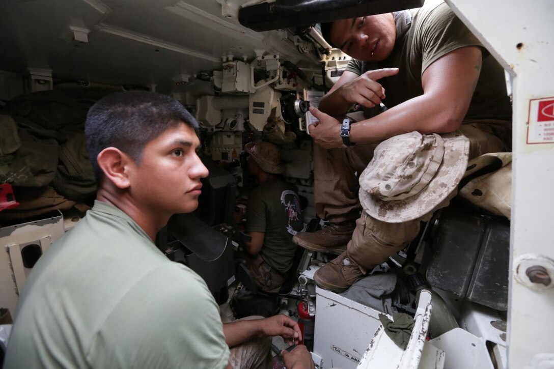 ARTA BEACH, Djibouti (July 24, 2015) U.S. Marine Cpl. Arvic Morales, right, shows Lance Cpl. Ricardo Mendoza the inner workings of an M1A1 Abrams tank. Morales is a tank gunner with Battalion Landing Team 3rd Battalion, 1st Marine Regiment, 15th Marine Expeditionary Unit. Mendoza is a mortar man with BLT 3/1, 15th MEU.   Elements of the 15th Marine Expeditionary Unit are ashore in Djibouti for sustainment training to maintain and enhance the skills they developed during their pre-deployment training period.  The 15th MEU is currently deployed in support of maritime security operations and theater security cooperation efforts in the U.S. 5th and 6th Fleet areas of operation. (U.S. Marine Corps photo by Sgt. Jamean Berry/Released)