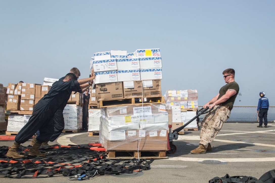 ARABIAN GULF (July 27, 2015) U.S. Marines and Sailors with the 15th Marine Expeditionary Unit and Essex Amphibious Ready Group assist with offloading packages aboard the dock landing ship USS Rushmore (LSD 47) during a replenishment-at-sea. The Marines and Sailors worked together to offload food, maintenance parts, and letters from home. The 15th MEU is embarked on the Essex Amphibious Ready Group and deployed to maintain regional security in the U.S. 5th Fleet area of operations. (U.S. Marine Corps photo by Sgt. Emmanuel Ramos/Released)