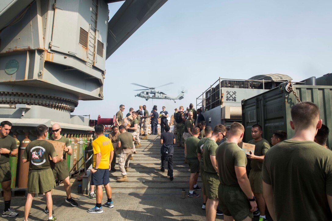 ARABIAN GULF (July 27, 2015) U.S. Marines and Sailors with the 15th Marine Expeditionary Unit and Essex Amphibious Ready Group assist with offloading packages aboard the dock landing ship USS Rushmore (LSD 47) during a replenishment-at-sea. The Marines and Sailors with the 15th MEU and Essex Amphibious Ready Group worked together to offload food, maintenance parts, and letters from home. The 15th MEU is embarked on the Essex Amphibious Ready Group and deployed to maintain regional security in the U.S. 5th Fleet area of operations. (U.S. Marine Corps photo by Sgt. Emmanuel Ramos/Released)