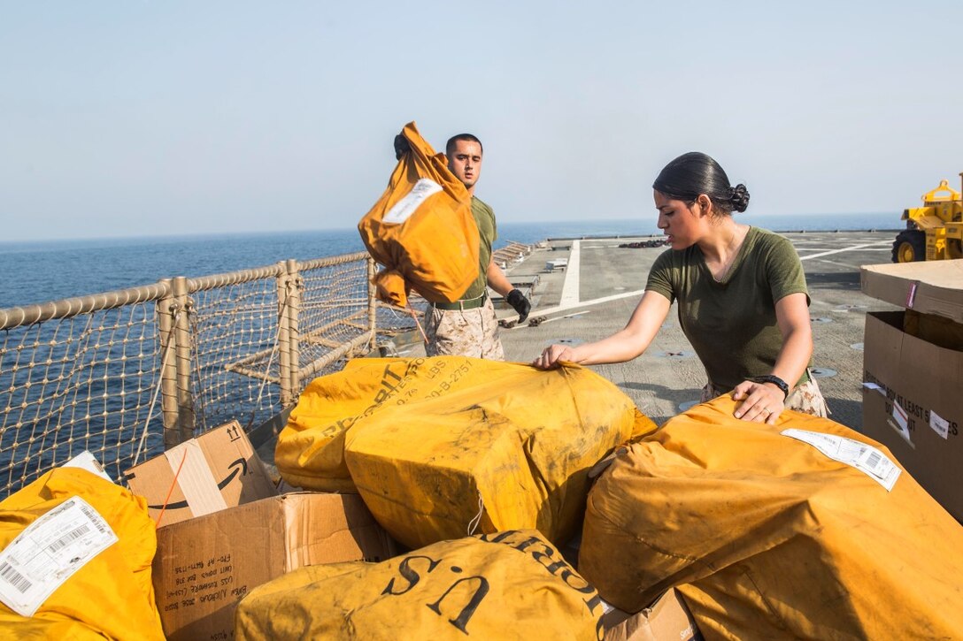 ARABIAN GULF (July 27, 2015) U.S. Marines and Sailors with the 15th Marine Expeditionary Unit and Essex Amphibious Ready Group assist with offloading mail aboard the dock landing ship USS Rushmore (LSD 47) during a replenishment-at-sea. The Marines and Sailors worked together to offload food, maintenance parts, and letters from home. The 15th MEU is embarked on the Essex Amphibious Ready Group and deployed to maintain regional security in the U.S. 5th Fleet area of operations. (U.S. Marine Corps photo by Sgt. Emmanuel Ramos/Released)