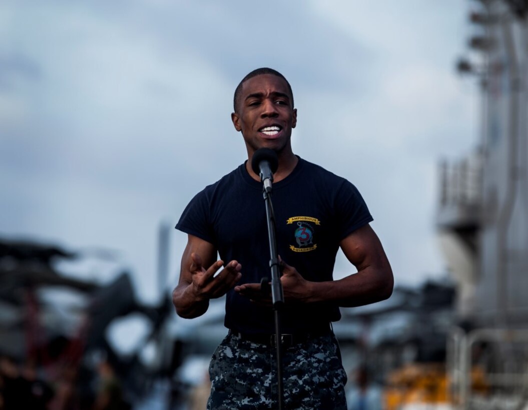 INDIAN OCEAN (July 29, 2015) Mass Communication Specialist 2nd Class Huey Younger recites an original poem during round three of the USS Essex’s “Gator’s Got Talent” talent show on the flight deck of the amphibious assault ship USS Essex (LHD 2). The Essex finds time to enhance unit moral by showcasing the talents of Sailors and Marines from the 15th Marine Expeditionary Unit and Essex Amphibious Ready Group and Essex. The 15th MEU is embarked on the Essex Amphibious Ready Group and deployed to maintain regional security in the U.S. 5th Fleet area of operations.  (U.S. Marine Corps photo by Cpl. Elize McKelvey/Released)