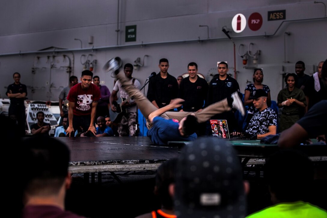 INDIAN OCEAN (July 29, 2015) Operations Specialist 3rd Class Damien Vang breakdances during round three of the USS Essex’s “Gator’s Got Talent” talent show on the flight deck of the amphibious assault ship USS Essex (LHD 2). The Essex finds time to enhance unit moral by showcasing the talents of Sailors and Marines from the 15th Marine Expeditionary Unit and Essex Amphibious Ready Group and Essex. The 15th MEU is embarked on the Essex Amphibious Ready Group and deployed to maintain regional security in the U.S. 5th Fleet area of operations. (U.S. Marine Corps photo by Cpl. Elize McKelvey/Released)