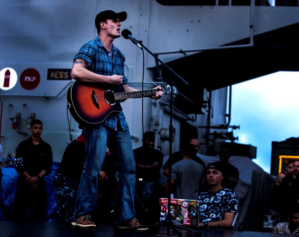 INDIAN OCEAN (July 29, 2015) Signalman Seth Clement sings and jams on his guitar during round three of the USS Essex’s “Gator’s Got Talent” talent show on the flight deck of the amphibious assault ship USS Essex (LHD 2). The Essex finds time to enhance unit moral by showcasing the talents of Sailors and Marines from the 15th Marine Expeditionary Unit and Essex Amphibious Ready Group and Essex. The 15th MEU is embarked on the Essex Amphibious Ready Group and deployed to maintain regional security in the U.S. 5th Fleet area of operations.  (U.S. Marine Corps photo by Cpl. Elize McKelvey/Released)