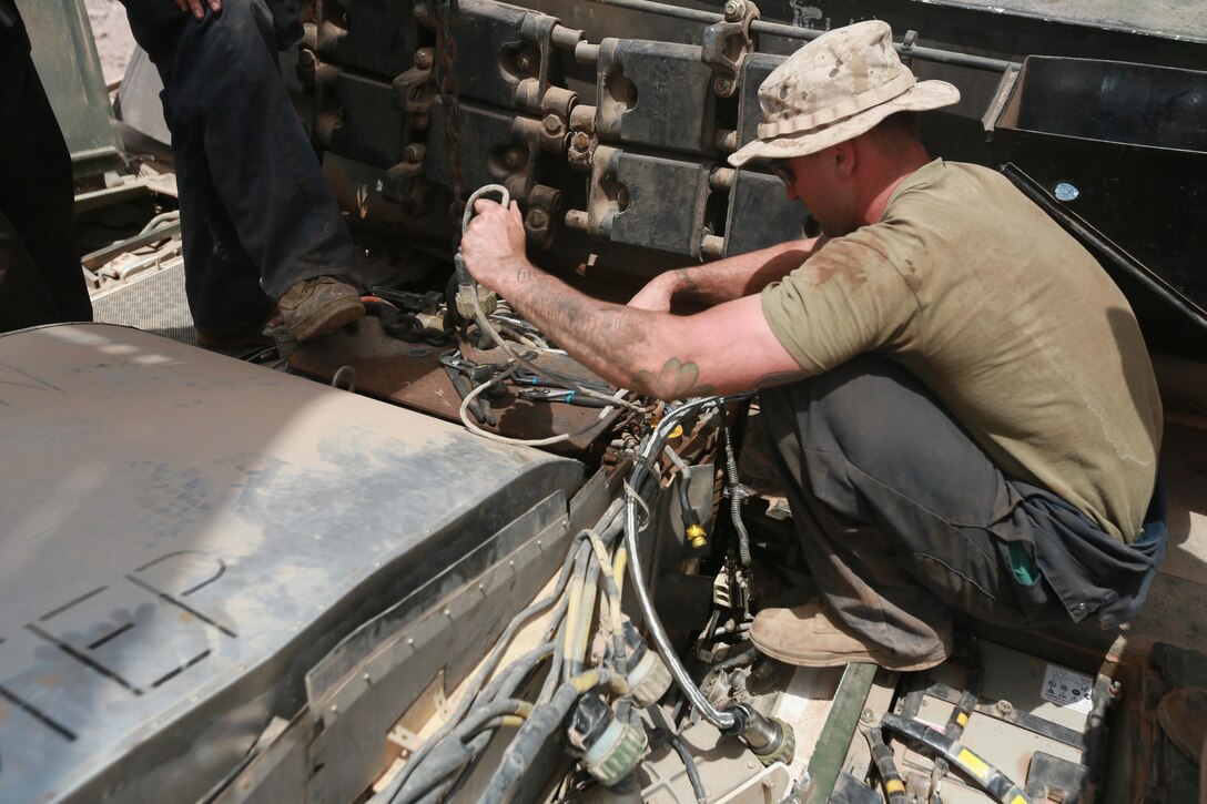 ARTA BEACH, Djibouti (July 25, 2015) U.S. Marine Sgt. Ryan Neville repairs a cable on the engine of an M1A1 Abrams tank during sustainment training. Neville is a tank mechanic with Combat Logistics Battalion 15, 15th Marine Expeditionary Unit. Elements of the 15th MEU are ashore in Djibouti for sustainment training to maintain and enhance the skills they developed during their pre-deployment training period.  The 15th MEU is currently deployed in support of maritime security operations and theater security cooperation efforts in the U.S. 5th and 6th Fleet areas of operation. (U.S. Marine Corps photo by Sgt. Steve H. Lopez/Released)