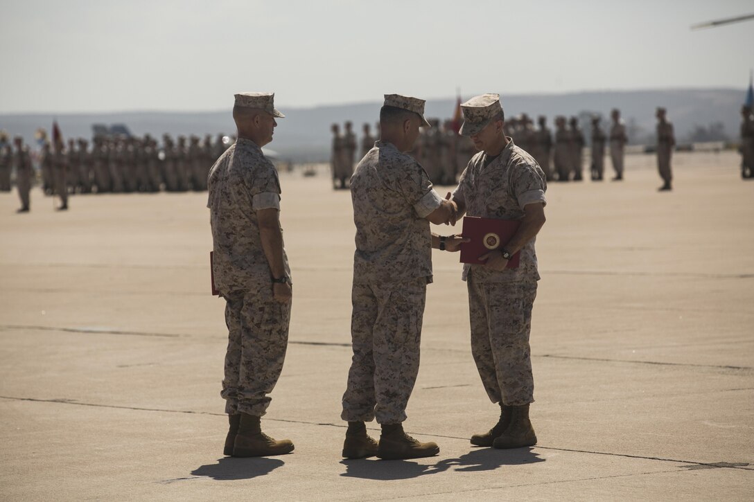 Maj. Gen. Mike Rocco, commanding general of 3rd Marine Aircraft Wing, presents the Legion of Merit to Col. Anthony Bianca, former commanding officer of Marine Aircraft Group (MAG) 16, during the MAG-16 change of command ceremony aboard Marine Corps Air Station Miramar, California, July 30. MAG-16 accumulated more than 60,000 flight hours, 1.1 million maintenance man-hours and flew more than 59,000 flight missions while Bianca commanded the group. (U.S. Marine Corps photo by Sgt. Brian Marion/Released)