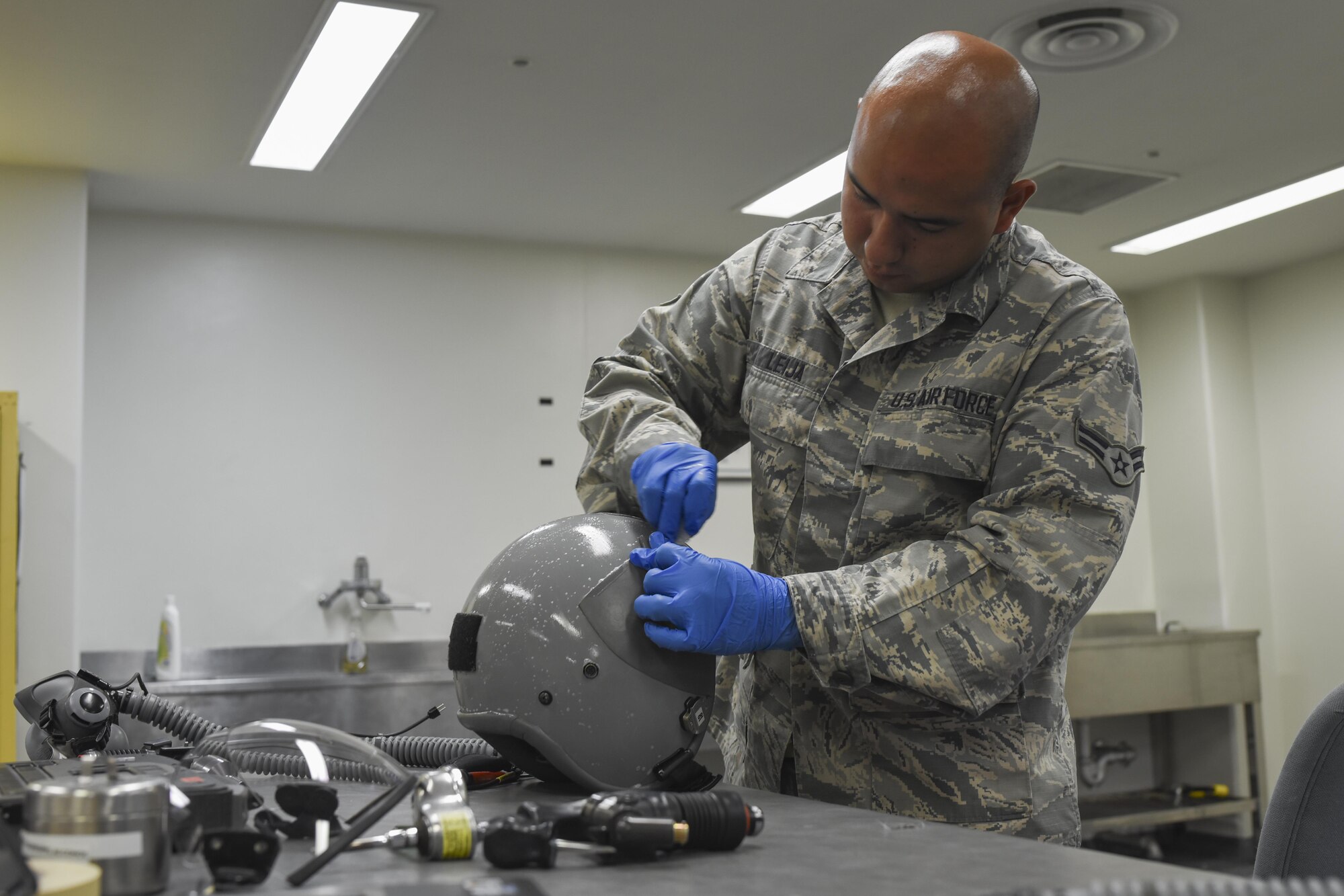 U.S. Air Force Airman 1st Class Raymundo Leija, 374th Operations Support Squadron aircrew flight equipment journeyman, cleans the outside of a helmet at Yokota Air Base, Japan, July 29, 2015. The AFE Airmen broke down, cleaned and inspected every part of the helmet to make sure everything was in working order. (U.S. Air Force photo by Senior Airman Michael Washburn/Released)
