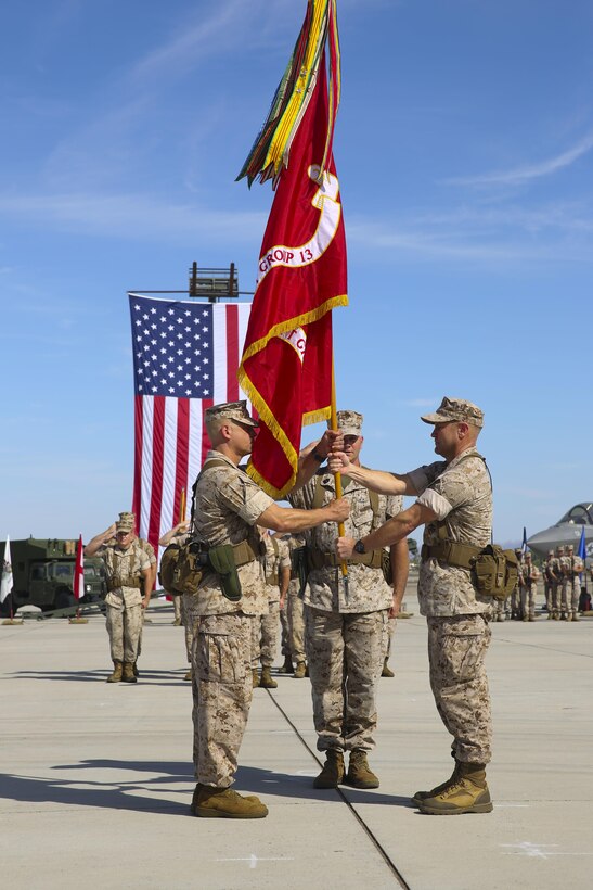 Col. Christopher A. McPhillips (right) passes the Marine Aircraft Group (MAG) 13 colors to Col. Marcus B. Annibale during a change of command ceremony aboard Marine Corps Air Station Yuma, Arizona, July 31. Annibale came from 1st Marine Air Wing where he served as the assistant chief of staff.