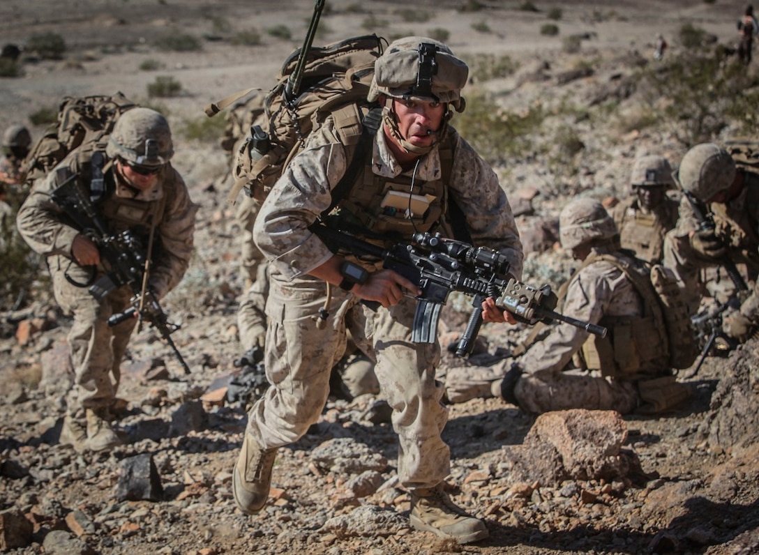 Machine gunners with Company C, 1st Battalion, 3rd Marine Regiment, sprint to a hilltop to establish a support by fire position in order to provide suppressing fires for several platoons of riflemen during an Integrated Training Exercise aboard Marine Corps Air Ground Combat Center Twentynine Palms, Calif., July 29. 