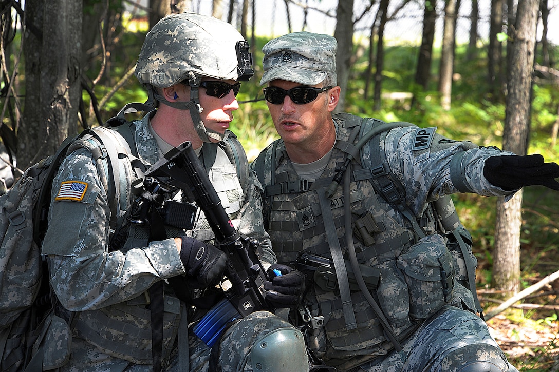 Army Sgt. 1st Class Shane Watts, right, provides movement instructions ...