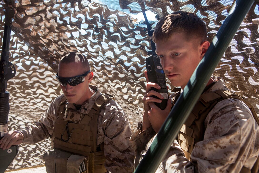 Marine Corps 1st Lt. Craig R. Waldman, left, listens to fire team engagement reports repeated by Marine Corps Lance Cpl. Steven J. Hotham during Exercise Red Flag 2015 at Tonopah Test Range, Nev., July 22, 2015. Waldman is a platoon commander and Hotham is a low altitude air defense gunner assigned to 2nd Low Altitude Air Defense Battalion, Bravo Battery. Red Flag is an advanced aerial combat exercise to train U.S., NATO, and other partners for air combat situations. 