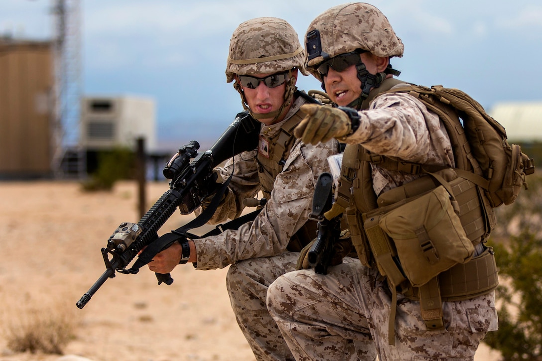 A Marine points in the direction of the next objective on a security patrol during an Integrated Training Exercise aboard Marine Corps Air Ground Combat Center Twentynine Palms, Calif., July 19, 2015.