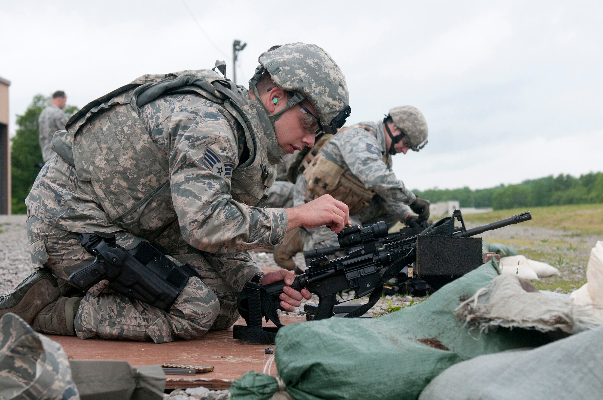 Senior Airman Richard Lunsford, a Combat Arms Training and Maintenance team member from the Kentucky Air National Guard's 123rd Security Forces Squadron, makes site adjustments on an M68 close combat optic attached to an M4 carbine during annual weapons qualifications training at Fort Knox, Kentucky, May 16, 2015. (U.S. Air National Guard photo by Staff Sgt. Vicky Spesard)